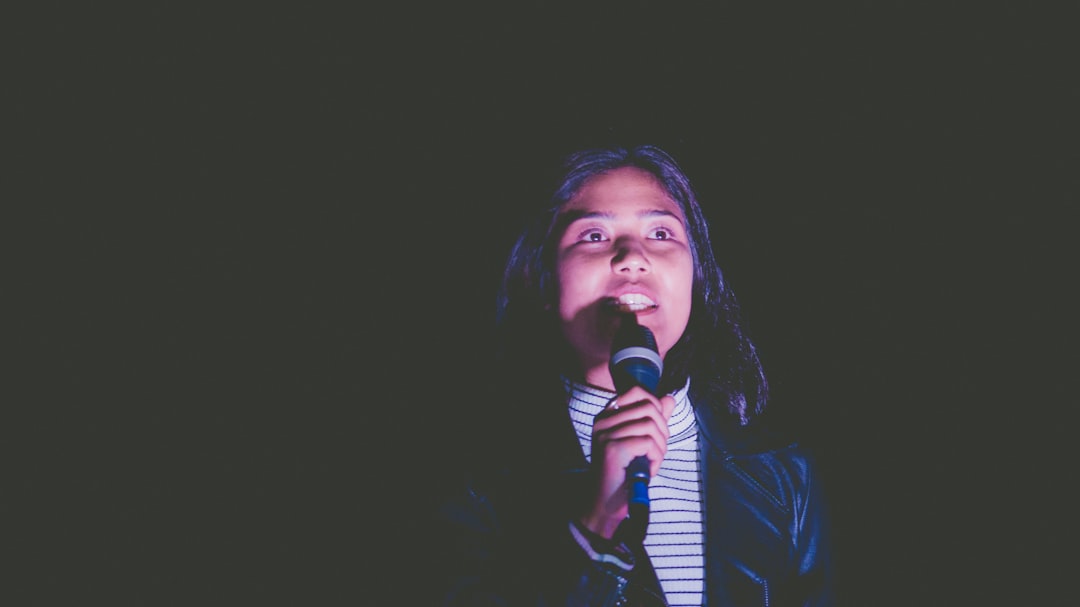 low-light photo of woman holding black microphone